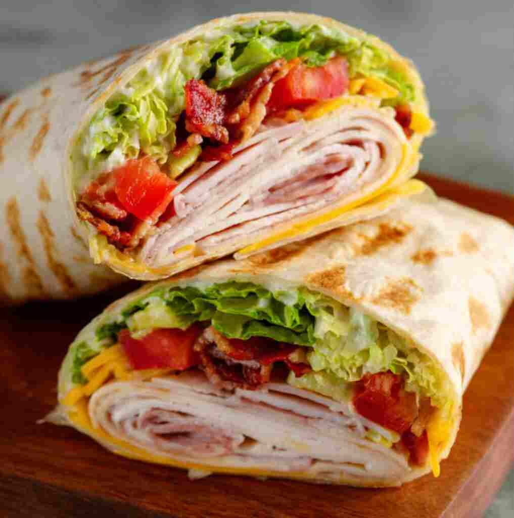 California Turkey Club Wrap - crispy golden skin with aromatic herb seasoning with fresh thyme leaves and roasted garlic cloves