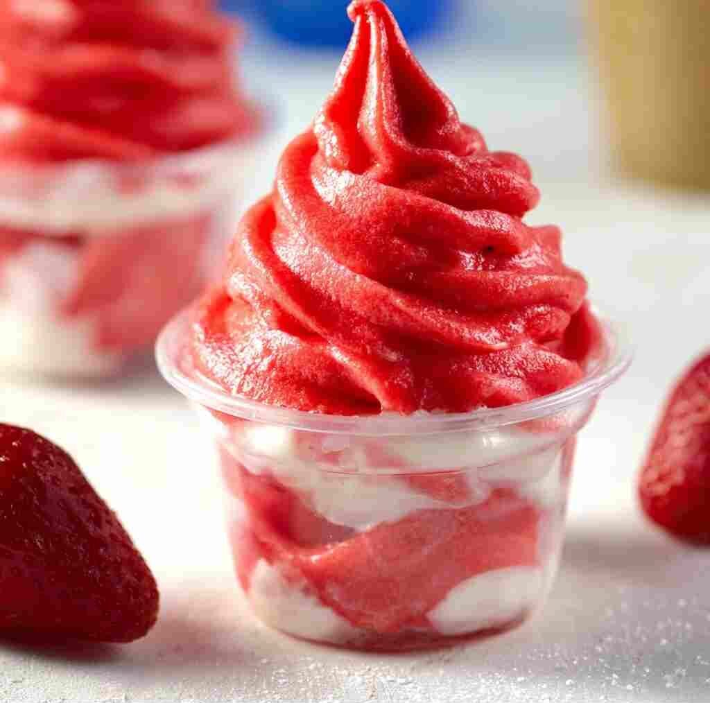 Easy Strawberry Dole Whip - frosted condensation with a delicate sugared rim and berry skewer